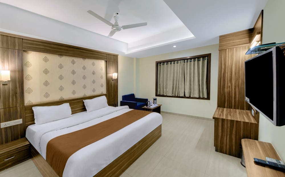 Hotel Shital Inn Deluxe Double Bed Room with bed, seating and television