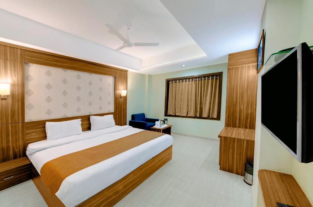 Hotel Shital Inn Deluxe Double Bed Room with double bed, seating and television