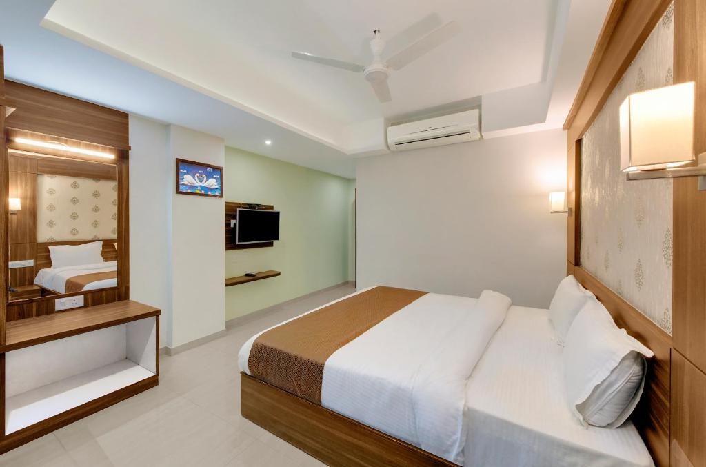 Hotel Shital Inn Deluxe Double Bed Room with vanity mirror, bed and television